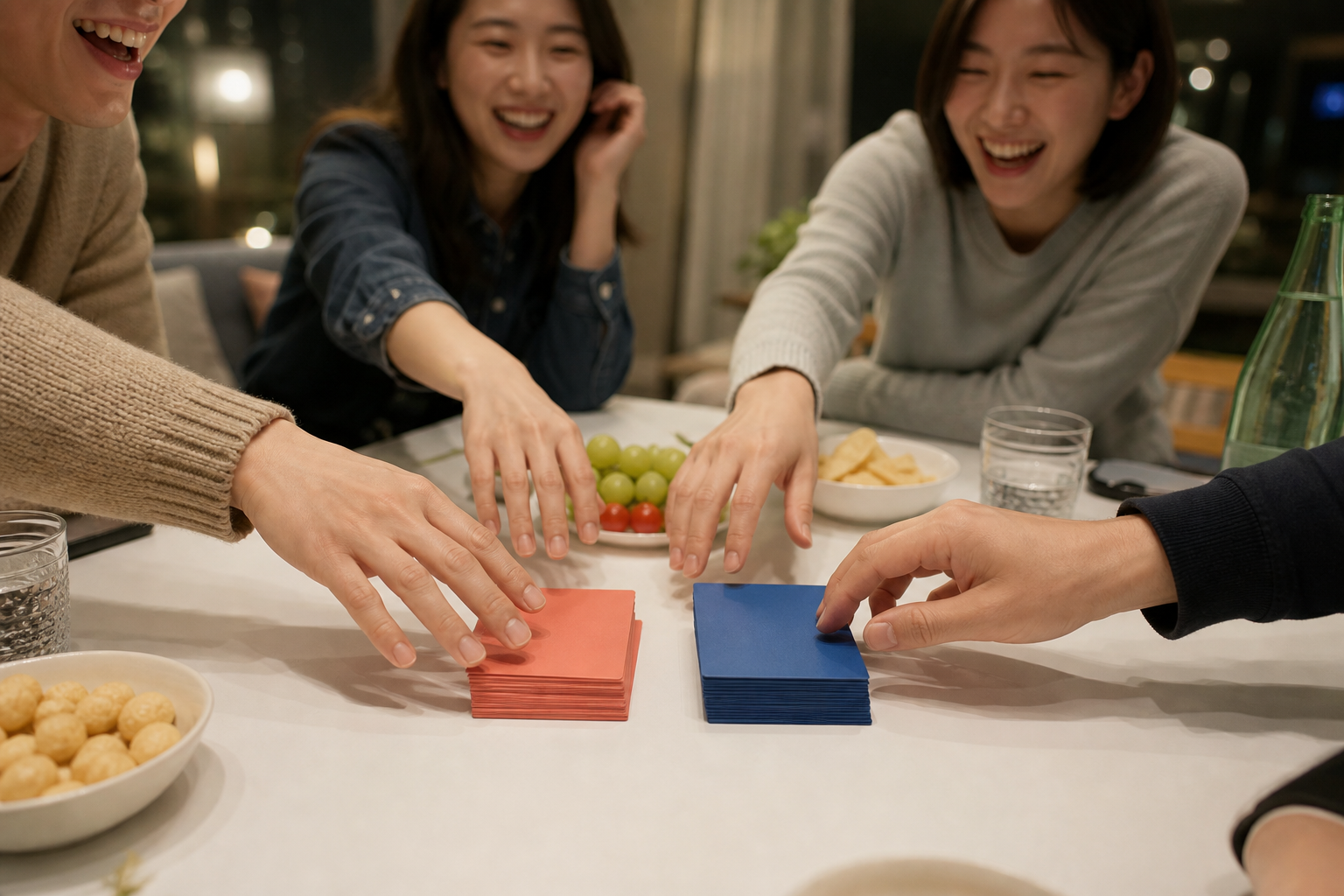 간식이 놓인 탁자 위 빨간색과 파란색 카드로 손을 뻗는 친구들